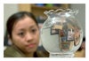 Photograph of a girl and room as seen in a spherical vase.