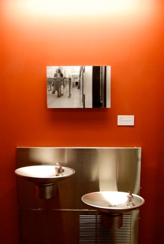 Photograph displayed above water fountains, viewed straight on.