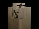 Photograph of bass wood cube model on basewith shifted portions of the cube.