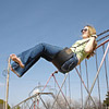 A photo of a woman, barefoot, on a swing.