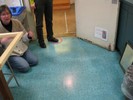 Photo of students standing and sitting on the floor and viewing a propped-up mirror.