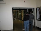 Photo of two students looking through the wooden frame from a distance.