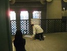 Photo of a student in front of a wooden frame with a sheet of paper silhouetting the railing against which it's attached.