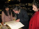 Photo of students gathered around and reading a historical text.