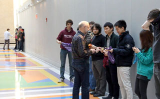 Students standing in a row while receiving number assignments from the professor.