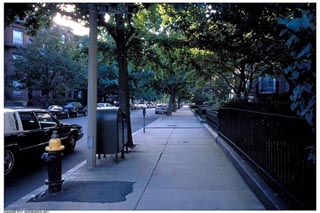 A photo looking down a wide sidewalk.